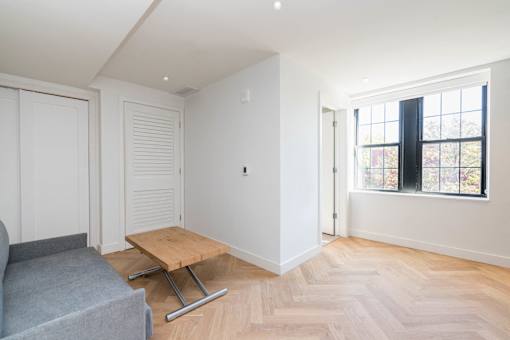 The Stanton furnished studio apartment with murphy bed, table and couch