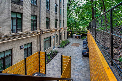 A view of a courtyard from a balcony with a black fence.