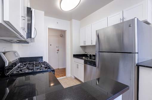 A kitchen with a stove top oven and a refrigerator.