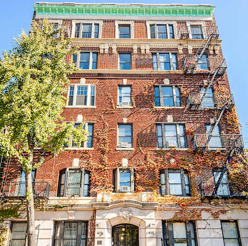 A red brick building with a tree in front of it.