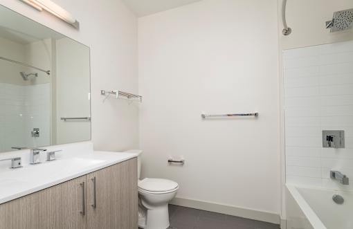 a bathroom with a toilet sink mirror and bathtub