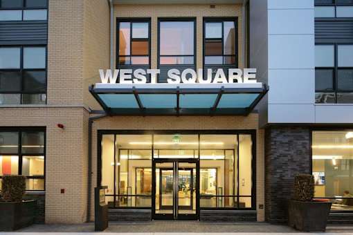 a large building with a sign that says west square on top of it