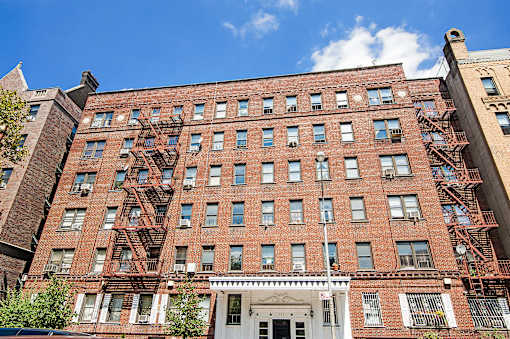A red brick building with a white door and windows.