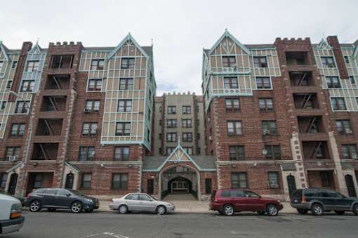 A large building with a green roof and a car parked in front.