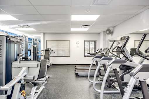 fitness center with cardio equipment and weights