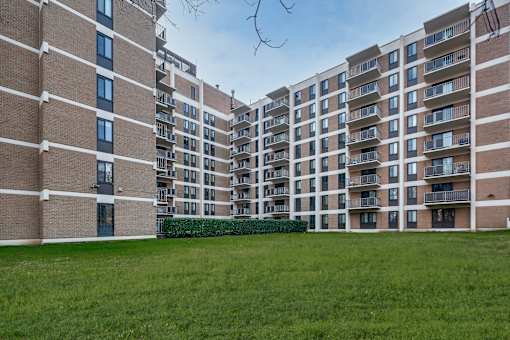 A large grassy area in front of apartment buildings.