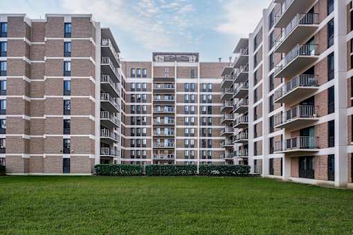 A large grassy area in front of apartment buildings.