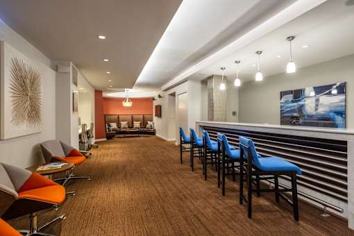 A long hallway with blue chairs on the right side.
