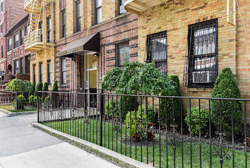 A row of houses with a black fence in front.