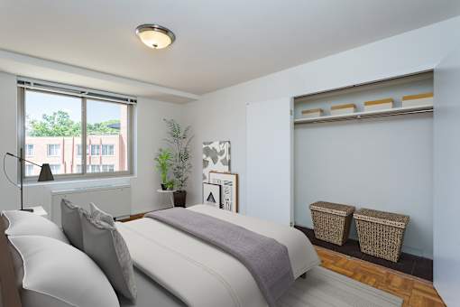 A bedroom with a large bed and a window overlooking a building.