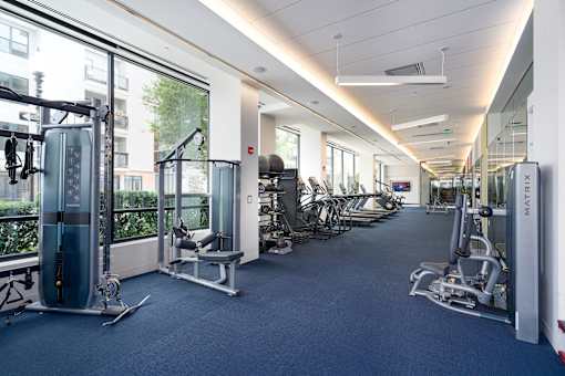 a fitness room with cardio machines and weights