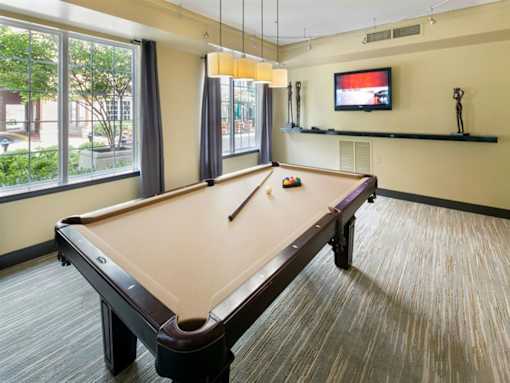 a games room with a pool table and a tv