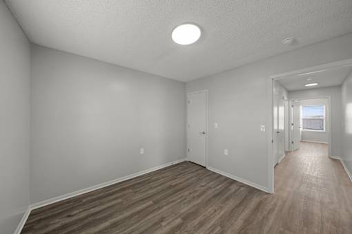 A room with wooden flooring and white walls.