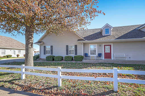 A house with a red door and a white fence.