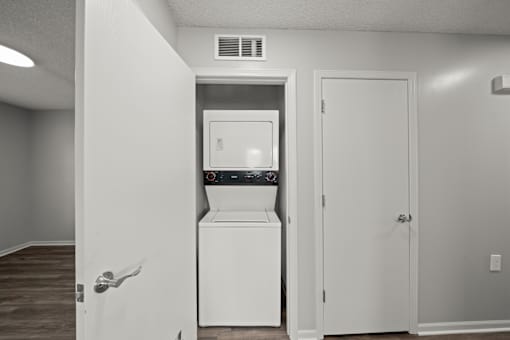 A white fridge in a room with a door open.