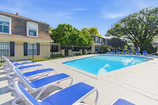 A pool surrounded by blue lounge chairs.