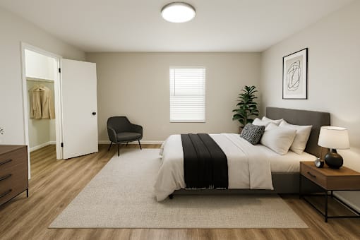 A bedroom with a bed, chair, and a plant.