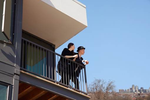 Two people are standing on a balcony.