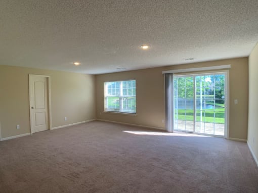 Photo of carpeted basement with sliding glass door