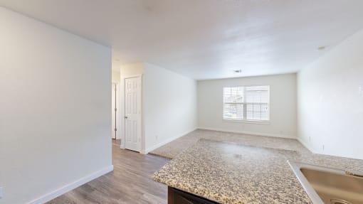 a kitchen and living room with white walls and wood flooring at Bennett Ridge Apartments, Oklahoma City, 73132