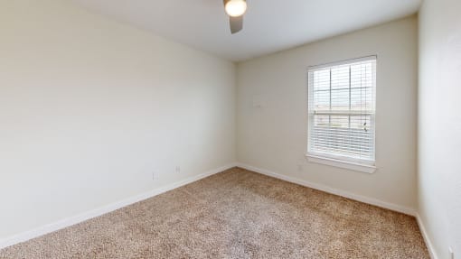 a bedroom with a ceiling fan and a window at Bennett Ridge Apartments, Oklahoma City, OK