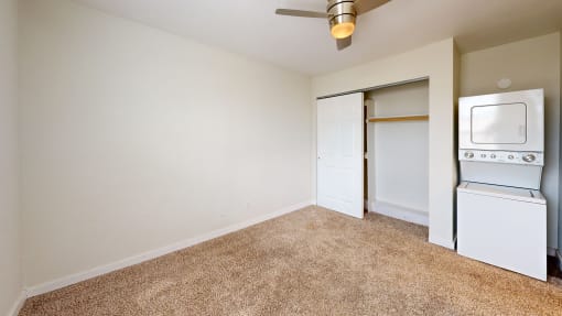 a bedroom with a ceiling fan and a washer and dryer at Bennett Ridge Apartments, Oklahoma City