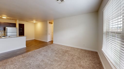 a bedroom with a large window and a kitchen in the background at Bennett Ridge Apartments, Oklahoma City, OK, 73132