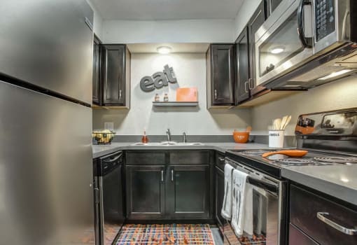 Fully equipped kitchen with stainless steel appliances, quartz countertops, and updated cabinets