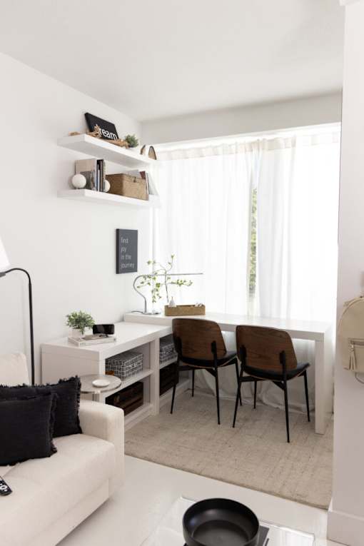 A white living room with a couch, chairs, and a table.