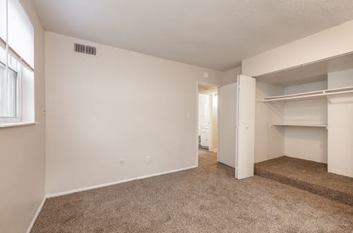 a bedroom with an open doorway and a carpeted floor