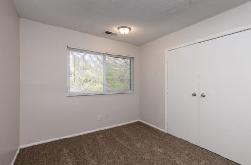 a bedroom with a window and a door