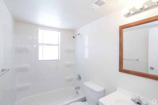 A white bathroom with a toilet, sink, and bathtub.