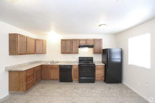 A kitchen with black appliances and wooden cabinets.