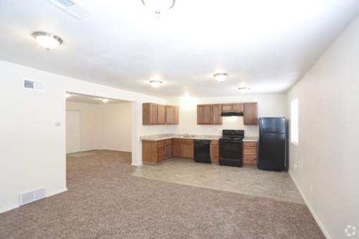 A kitchen with black appliances and brown cabinets.