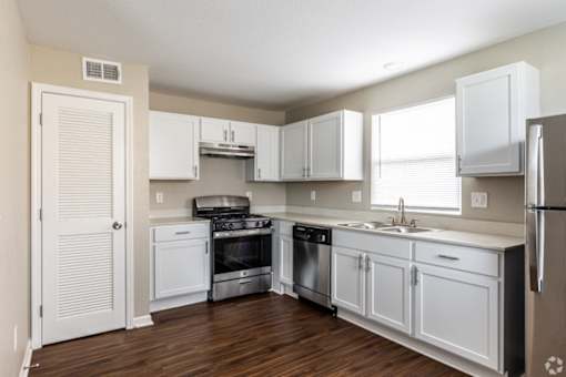 A kitchen with white cabinets and appliances.