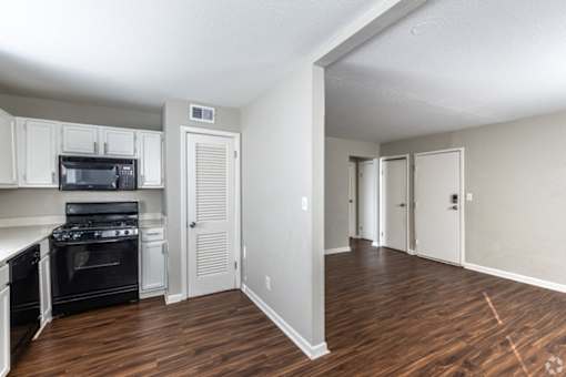 A kitchen with white cabinets and a black stove top oven.