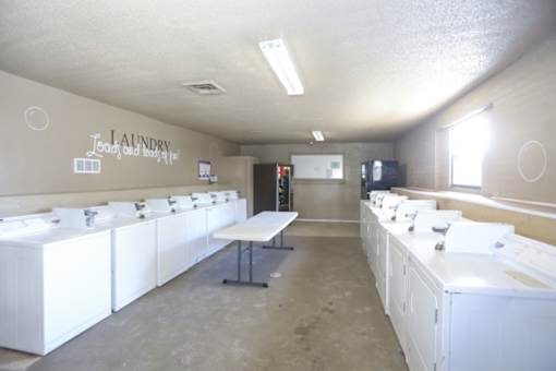 Laundry and dryer room with white washers and dryers.
