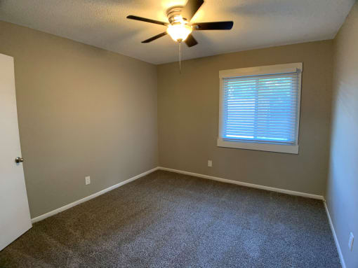 carpeted bedroom with large closet and ceiling fan