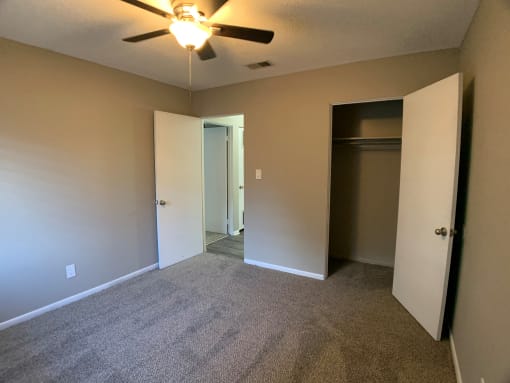 carpeted bedroom with large closet and ceiling fan