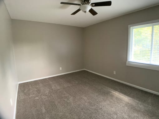 carpeted bedroom with large closet and ceiling fan