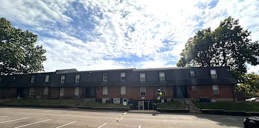 A large brick building with a parking lot in front.