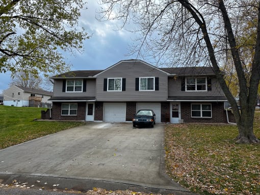 a large house with a car parked in the driveway