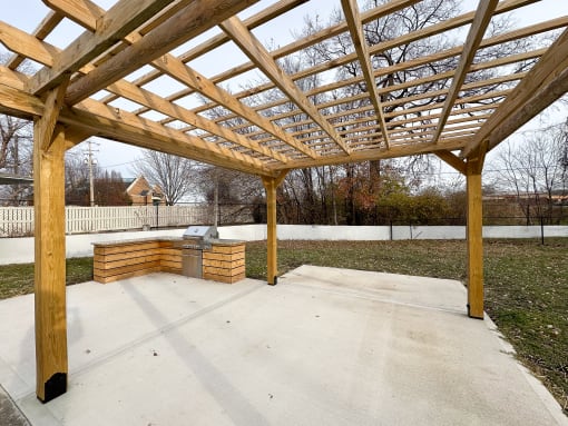 a patio with a wooden structure and a fire pit