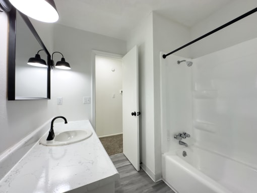 a bathroom with a sink and a tub and a shower