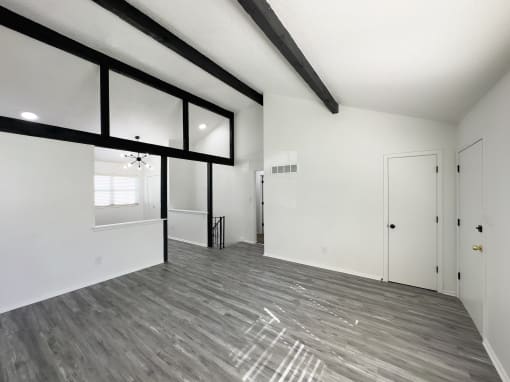 the living room of a new home with white walls and wood flooring