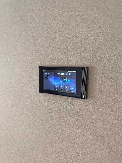 A digital thermostat is mounted on a wall.