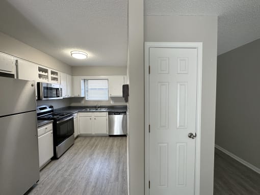 a kitchen with white cabinets and stainless steel appliances