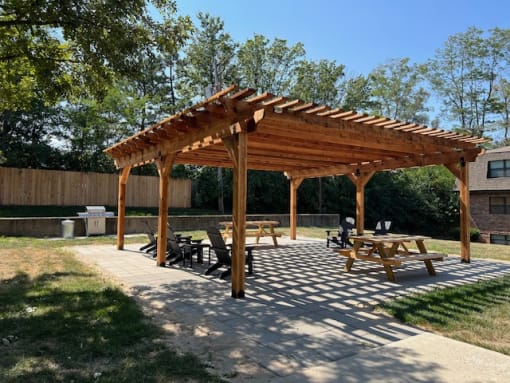 a wooden pergola with a stone patio