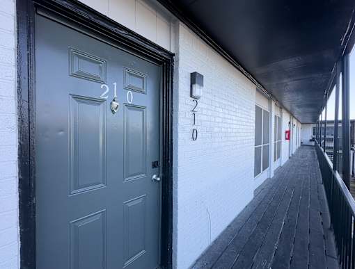 A black door with the number 210 on it.