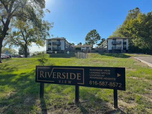 a view of riverside view apartments from the street with a sign